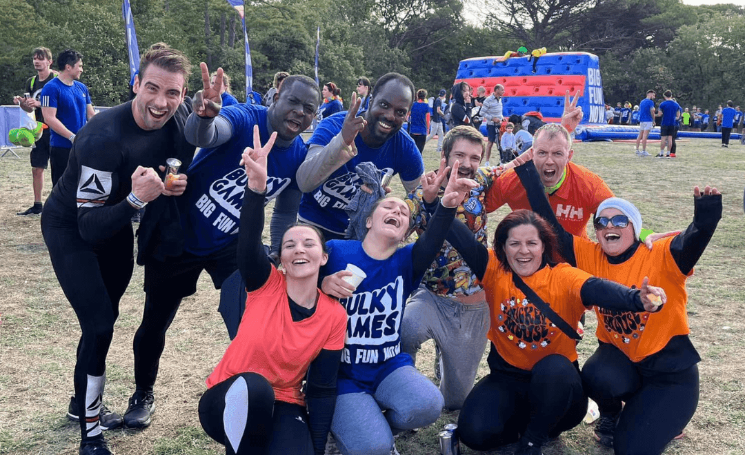 Un groupe de filles et garçons souriants et heureux, faisant un selfie ensemble, tous tenant leur téléphone avec l'application Frimake ouverte à l'écran.